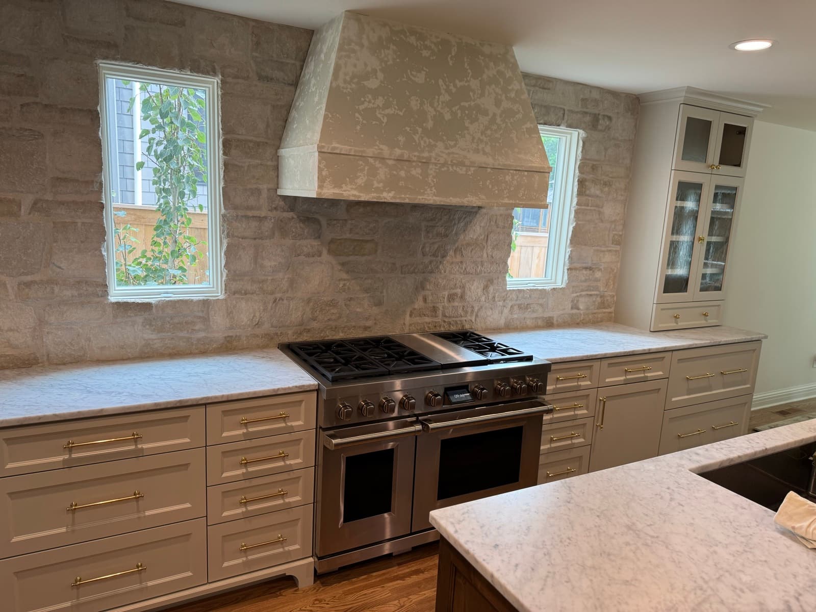 Custom kitchen with plaster range hood and stone surround
