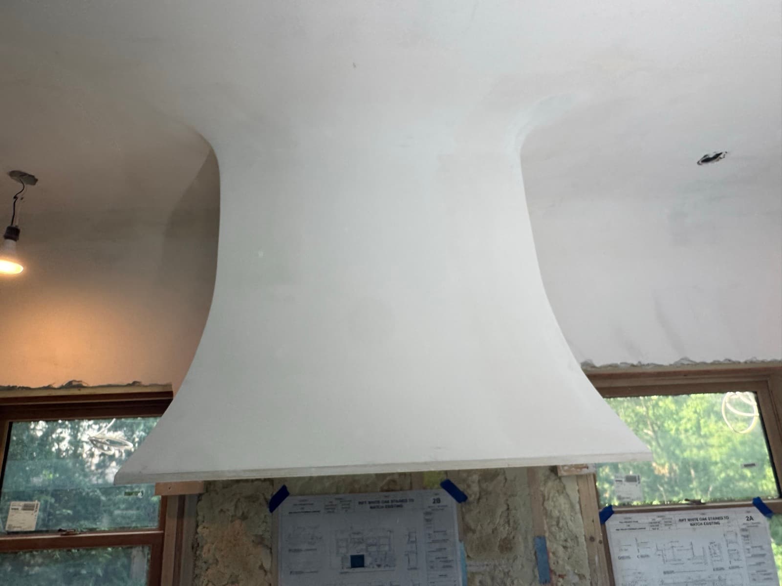 Curved white plaster range hood